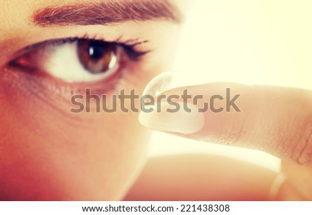 Close up of a woman putting contact lens in her eye