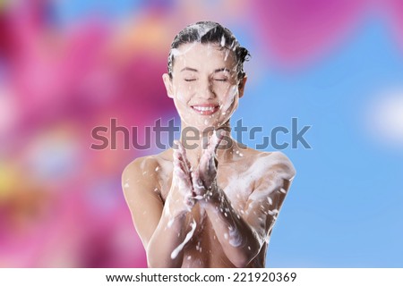 Young fit beautiful woman in shower washing her perfect fit body
