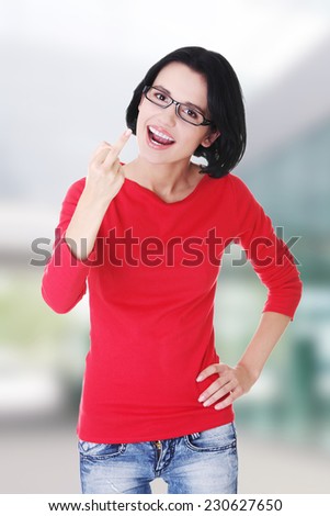 Young woman making obscene hand gesture by showing middle finger