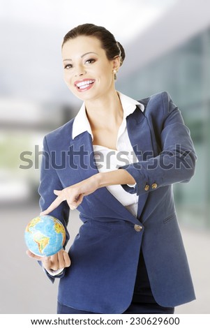 Young business woman holding small globe