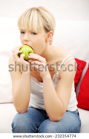 Portrait of beautiful woman eating an apple.