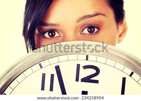 Portrait of shocked woman with clock over white background