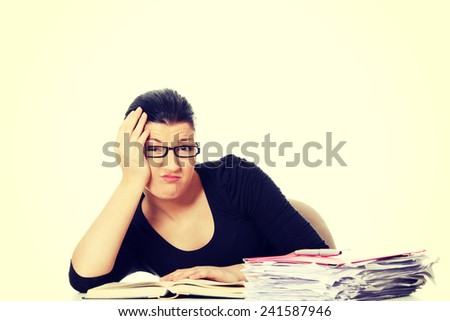 Woman filling out tax forms while sitting at her desk.