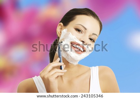 Young happy woman shaving face