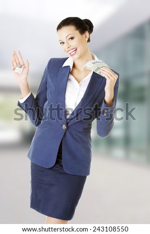Beautiful young business woman with money and keys