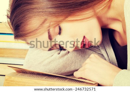 Beautiful woman is sleeping on a book. Student and education concept.