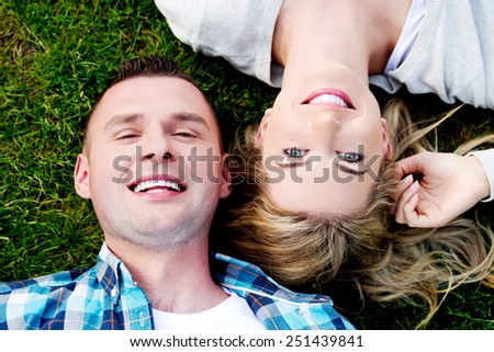 Young beautiful couple in love lying on the grass - Stock Image ...