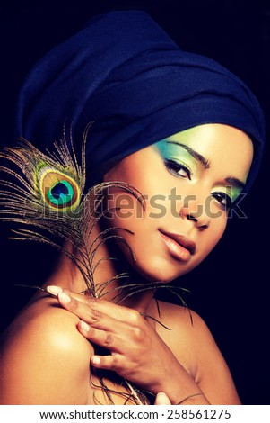 Beauty woman with artistic make up and peacock feather.