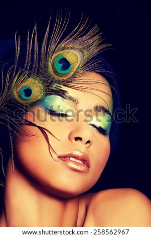 Beauty woman with artistic make up and peacock feather.