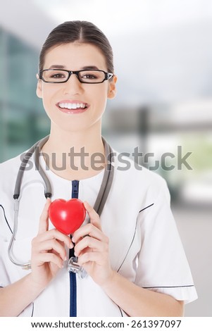 Beautiful young female doctor holding a heart