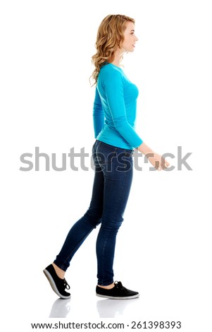 Side view of a woman walking slowly.