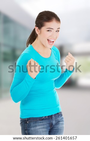 Excited happy success young woman with fists up.