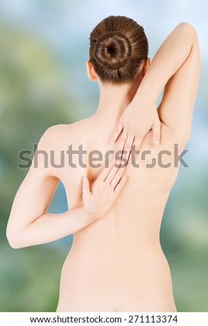 Naked woman with her hands connected on back.