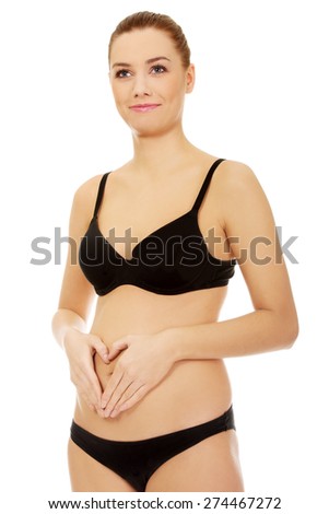 Fit and slim young woman touching her belly.