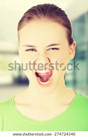 Young casual woman screaming with anger.