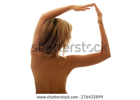 Back view portrait of naked woman with arms up.