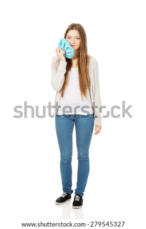 Teen woman with toothache and ice bag.