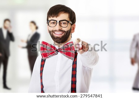 Funny man wearing suspenders pointing on you with big pencil.