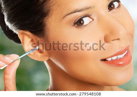 Beauty woman is cleaning her ear with cotton bud.