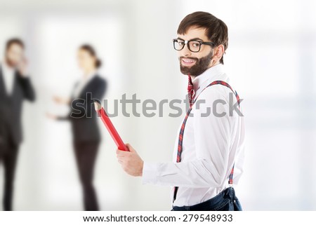 Funny man wearing suspenders pointing with big pencil.