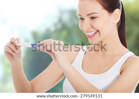 Happy smiling woman with pregnancy test.