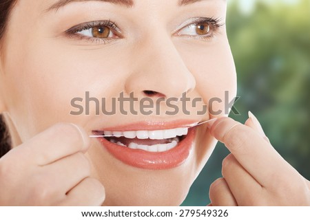 Happy young woman flossing teeth.