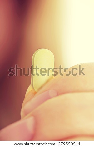 Woman with pill in hand