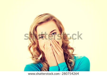 Woman giggles covering her mouth with hand