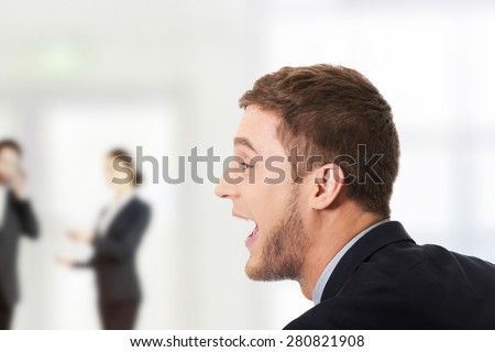 Frustrated businessman screaming at someone.