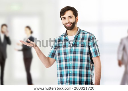 Young caucasian man showing something on palm.