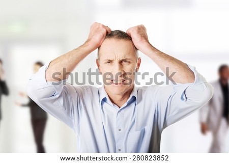 Frustrated mature man pulling his hair.