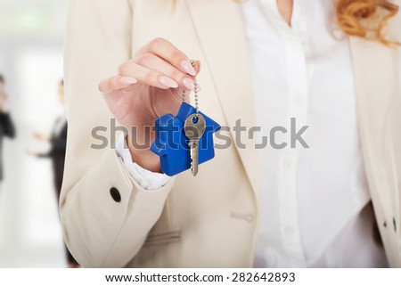 Businesswoman real estate agent giving keys.