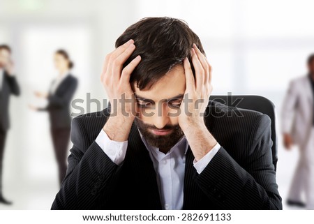 Tired businessman sitting at the desk.