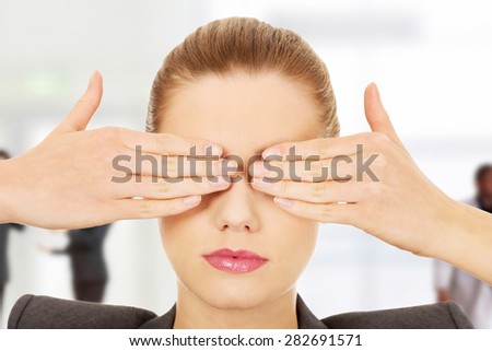Young businesswoman covering eyes with hands.