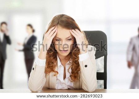 Beautiful worried businesswoman at the desk.