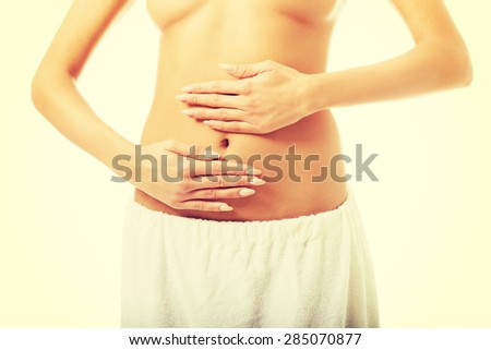 Spa woman in towel massaging slim belly.