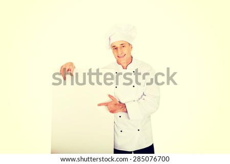 Chef in white uniform holding empty banner.