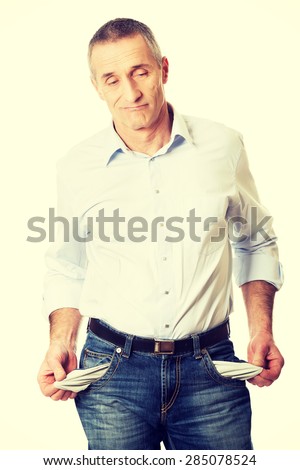Confused man showing his empty pockets.