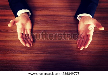 Close up of businessman open hands on the desk.