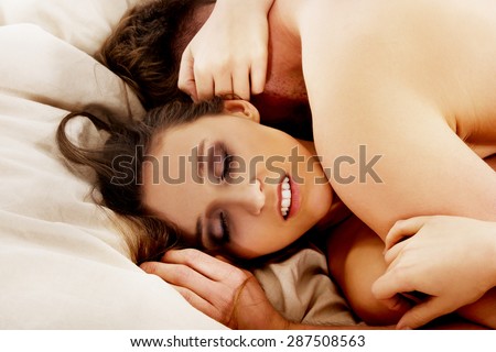 Heterosexual couple having sex in bedroom.