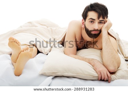 Young handsome depressed man in bed.