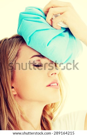 Beautiful woman with ice bag, having headache.