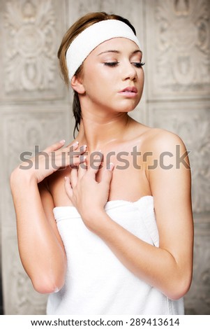 Attractive young woman wrapped in towel in bathroom.