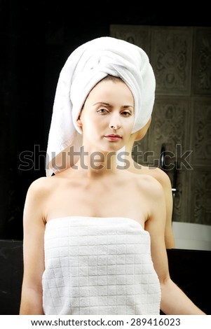 Beautiful woman wrapped in towel at bathroom.