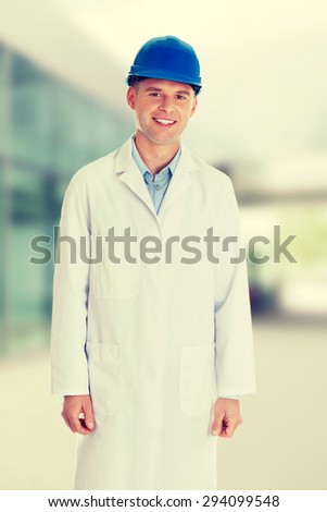 Man in a lab coat and helmet, engineer, teacher or chemical