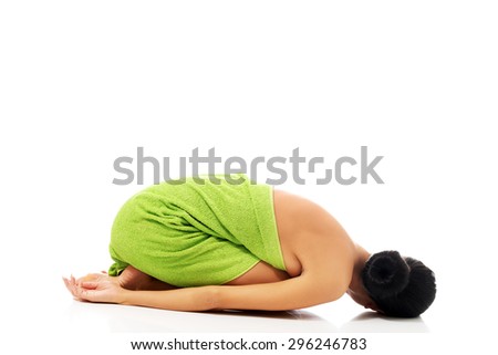 Spa woman curled up wrapped in towel.