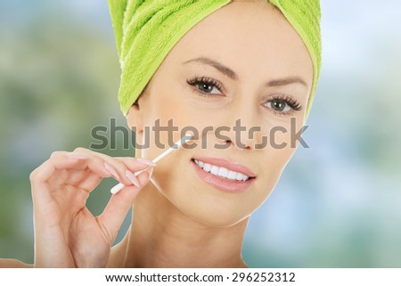 Beauty woman removing make up with cotton bud.