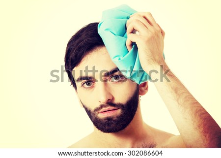 Man with headache and ice bag on his head.