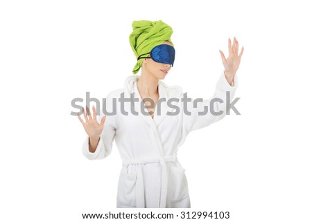 Sleepwalking woman in bathrobe and sleep bandage.