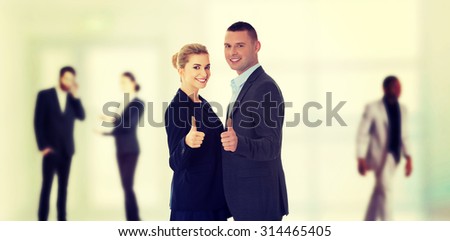 Happy business couple showing thumbs up.